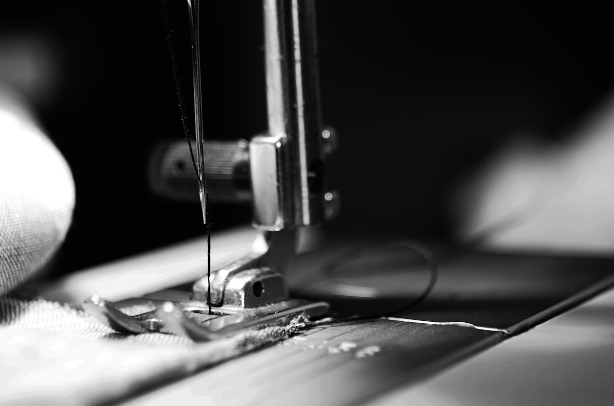 Close-up of a sewing machine needle stitching fabric